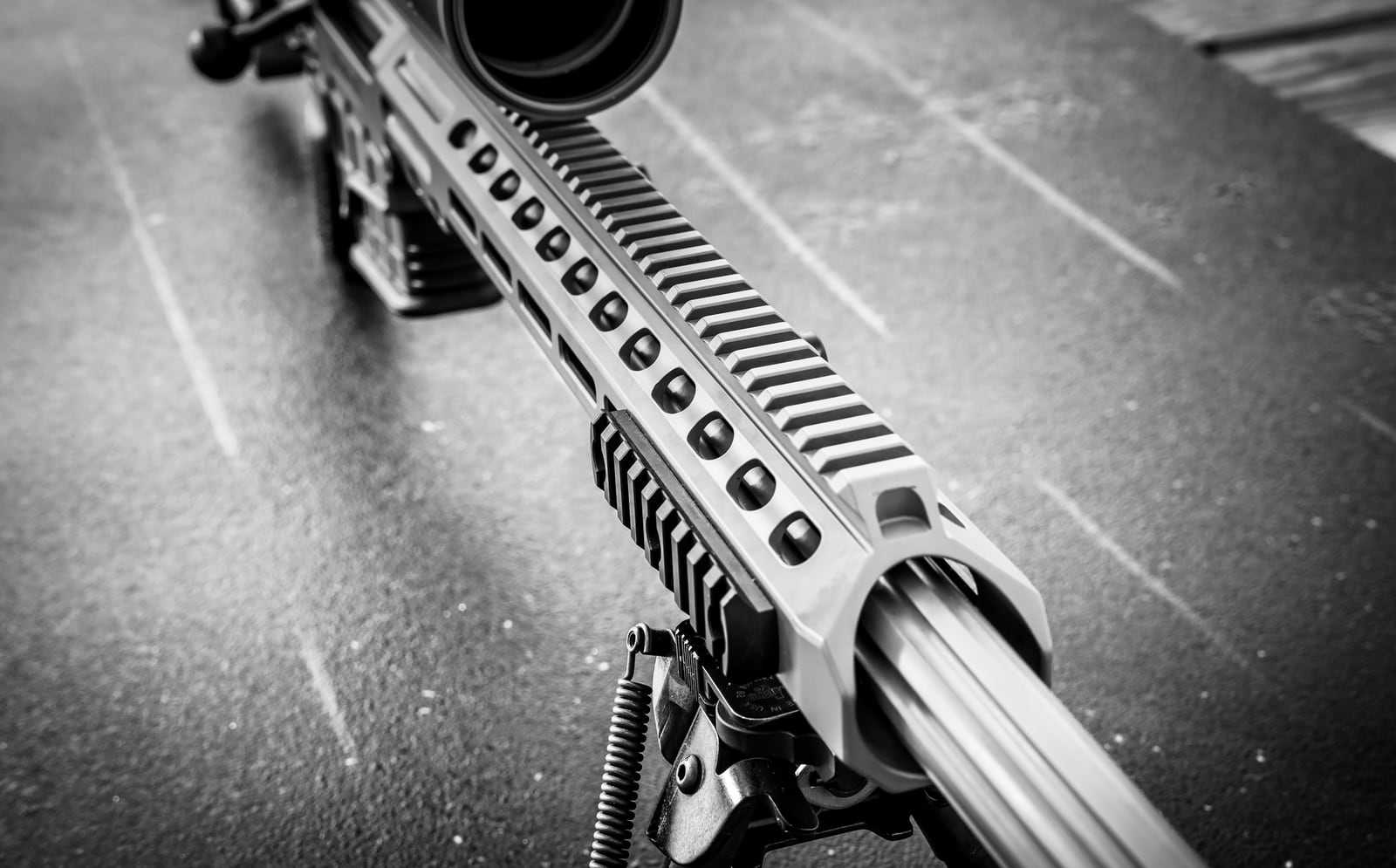 Top view of the MK 22 fluted barrel, M-LOK handguard and bipod on a range mat, black and white