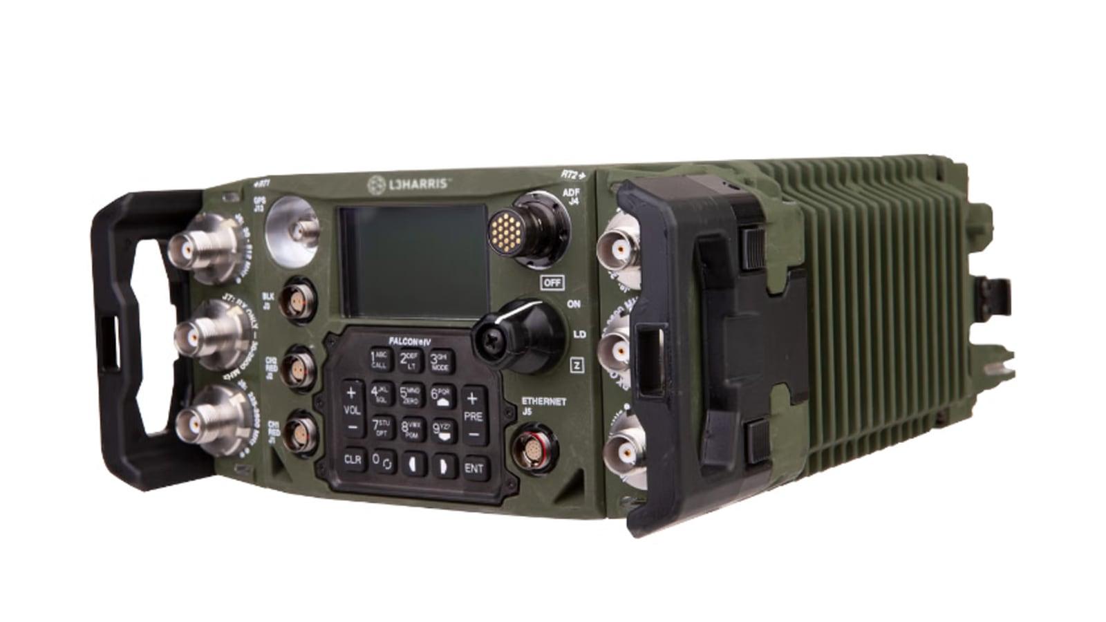 A green dual-channel manpack radio with keypad, display and antenna connectors on each side